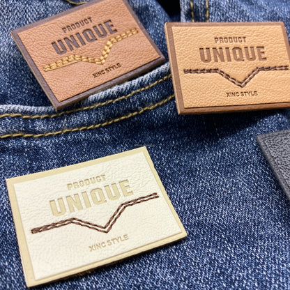 Юқори сифатли махсус ювилиши мумкин бўлган нақшинкор логотип жинси кўйлаги учун ПУ тери ёрлиғи ёрлиғига тикилган