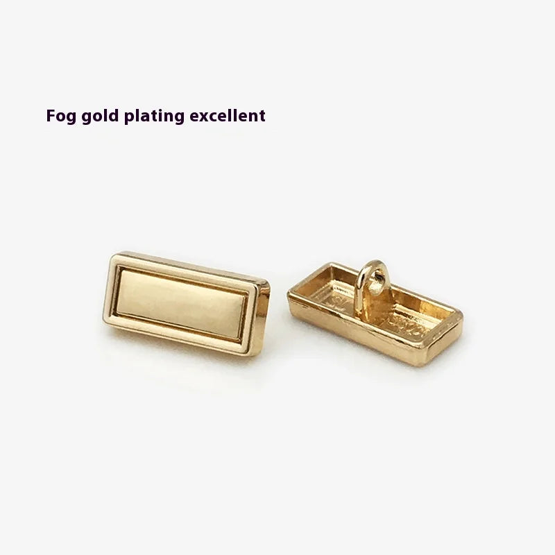 Оддий костюм ва пальто тугмаси — экологик тоза, металл тусли олтин рангдаги тўртбурчак шаклли декоратив тугма. Кийим учун аксессуар сифатида ишлатилади. Платировка (юза қопламаси) билан ясалган